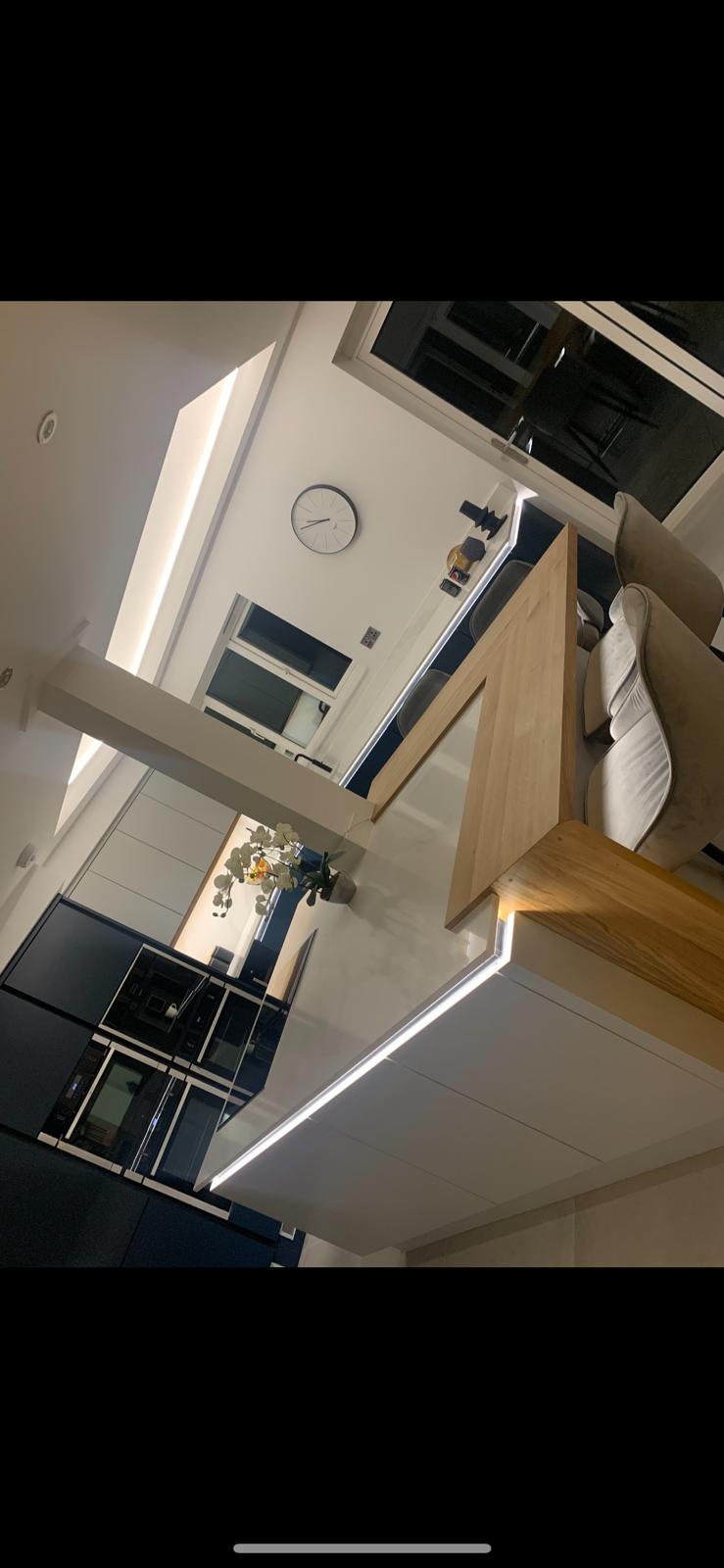 Modern handleless kitchen with navy units, oak breakfast bar and LED-lit island