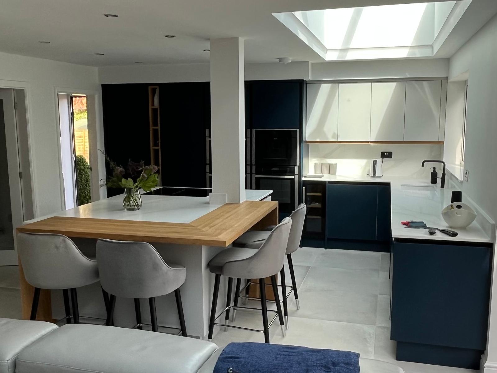Open-plan kitchen extension with skylight, navy cabinetry and oak breakfast bar