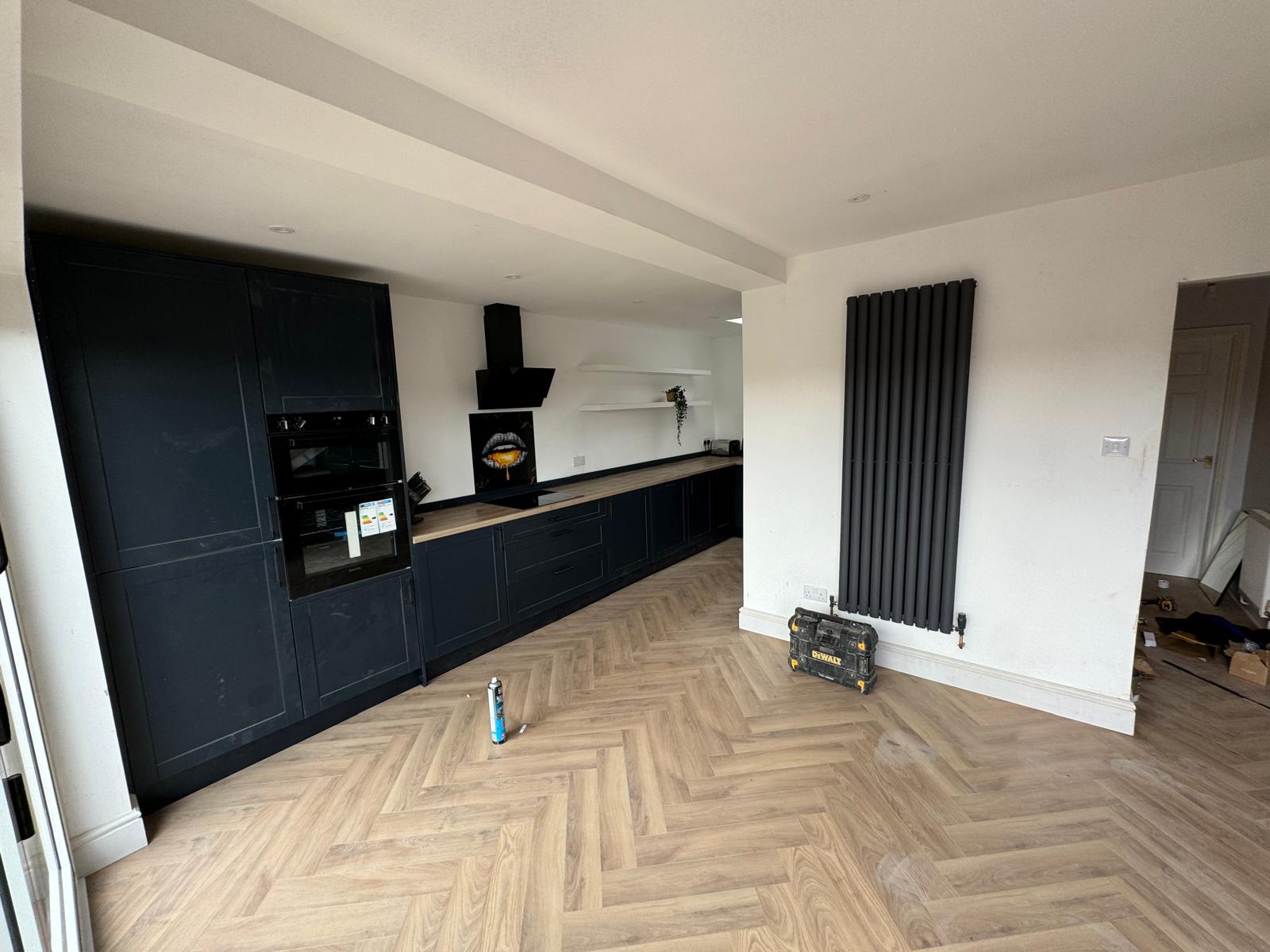 All-Black Handleless Kitchen with Herringbone LVT